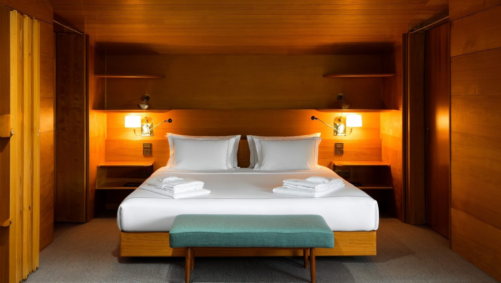 Deluxe cabin interior with vaulted cedar ceiling and a made bed