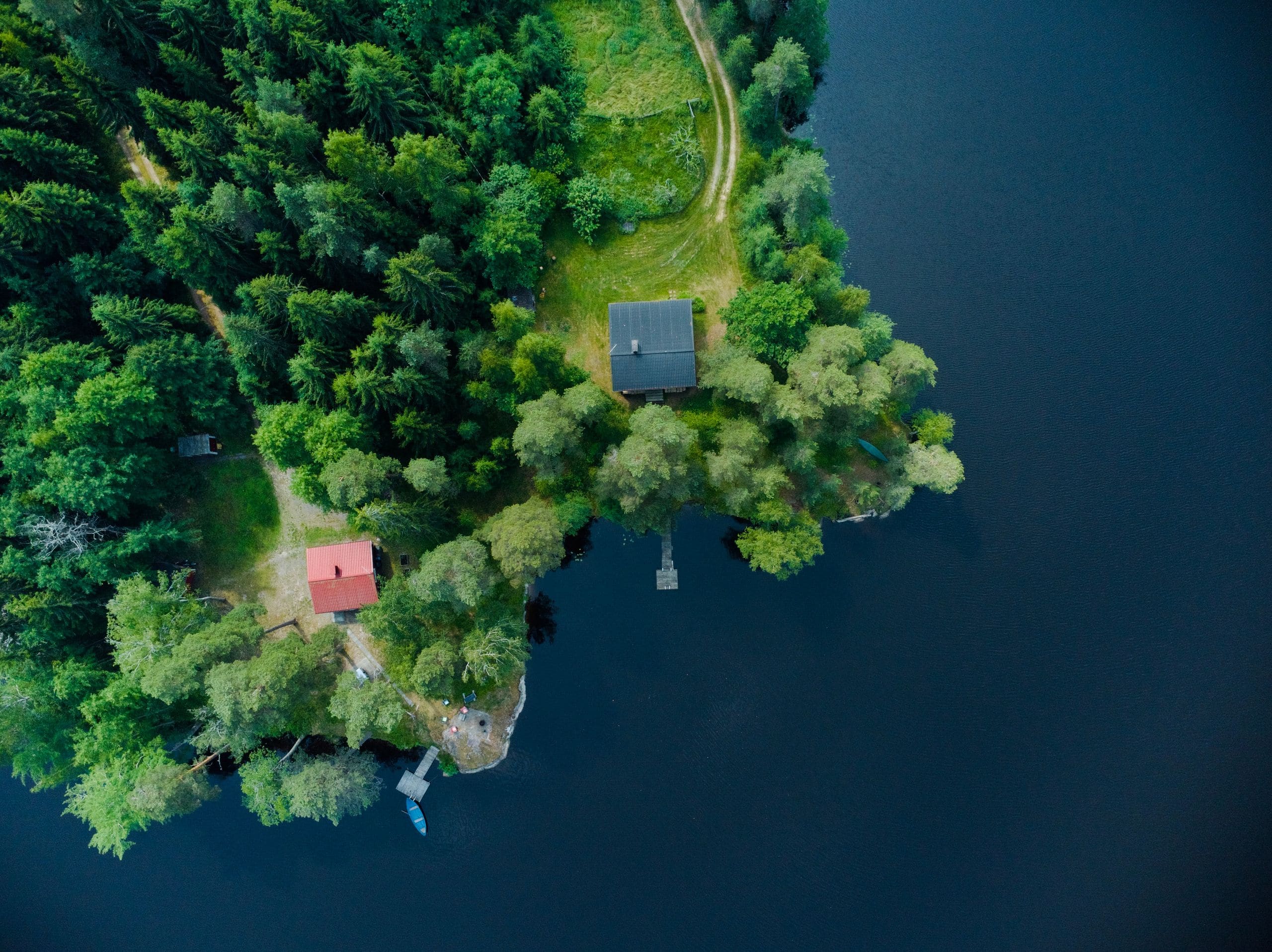 Aerial drone view of a row of deluxe cedar cabins nestled among the evergreens