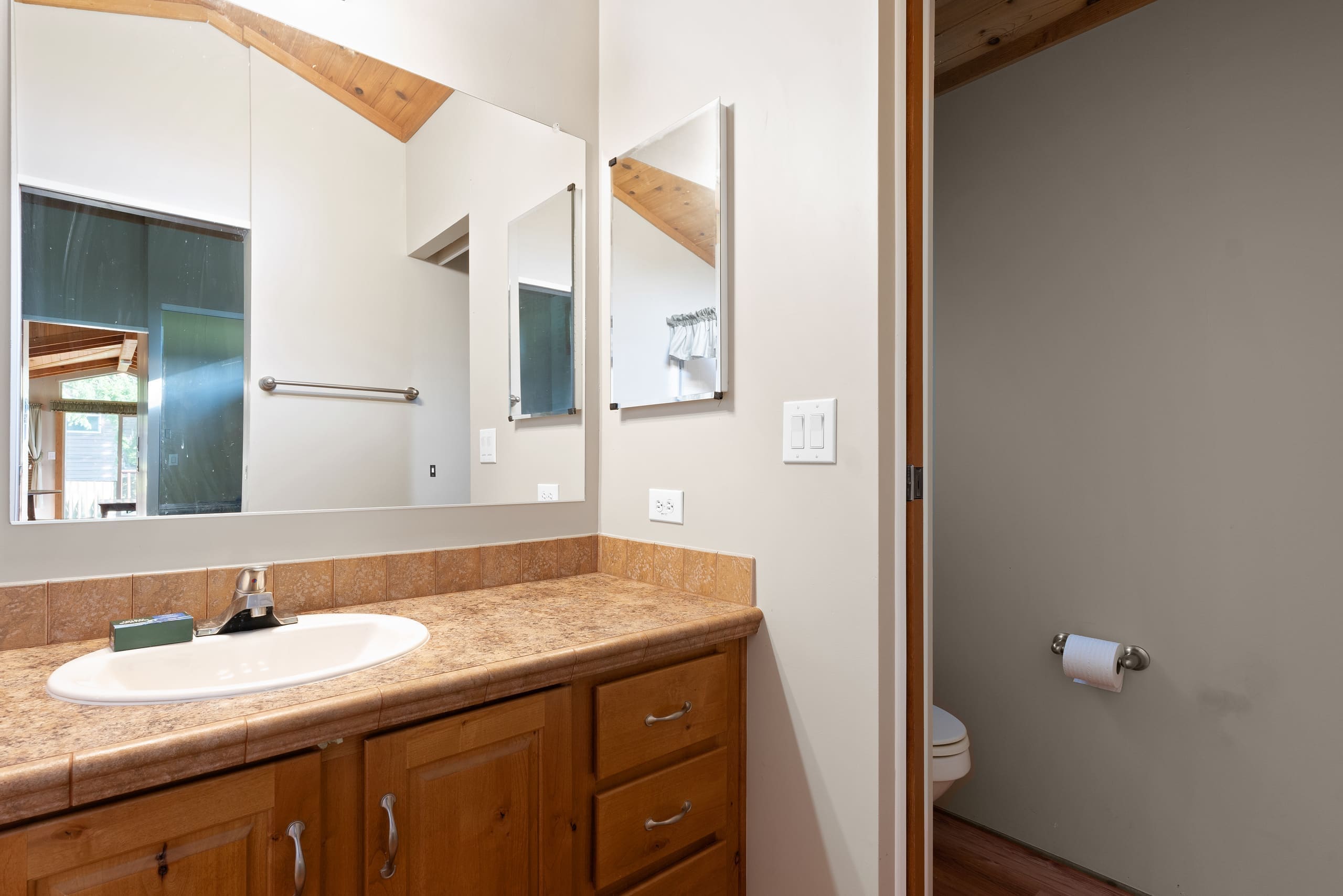 Cabin bathroom vanity with mirrors and tiled countertop