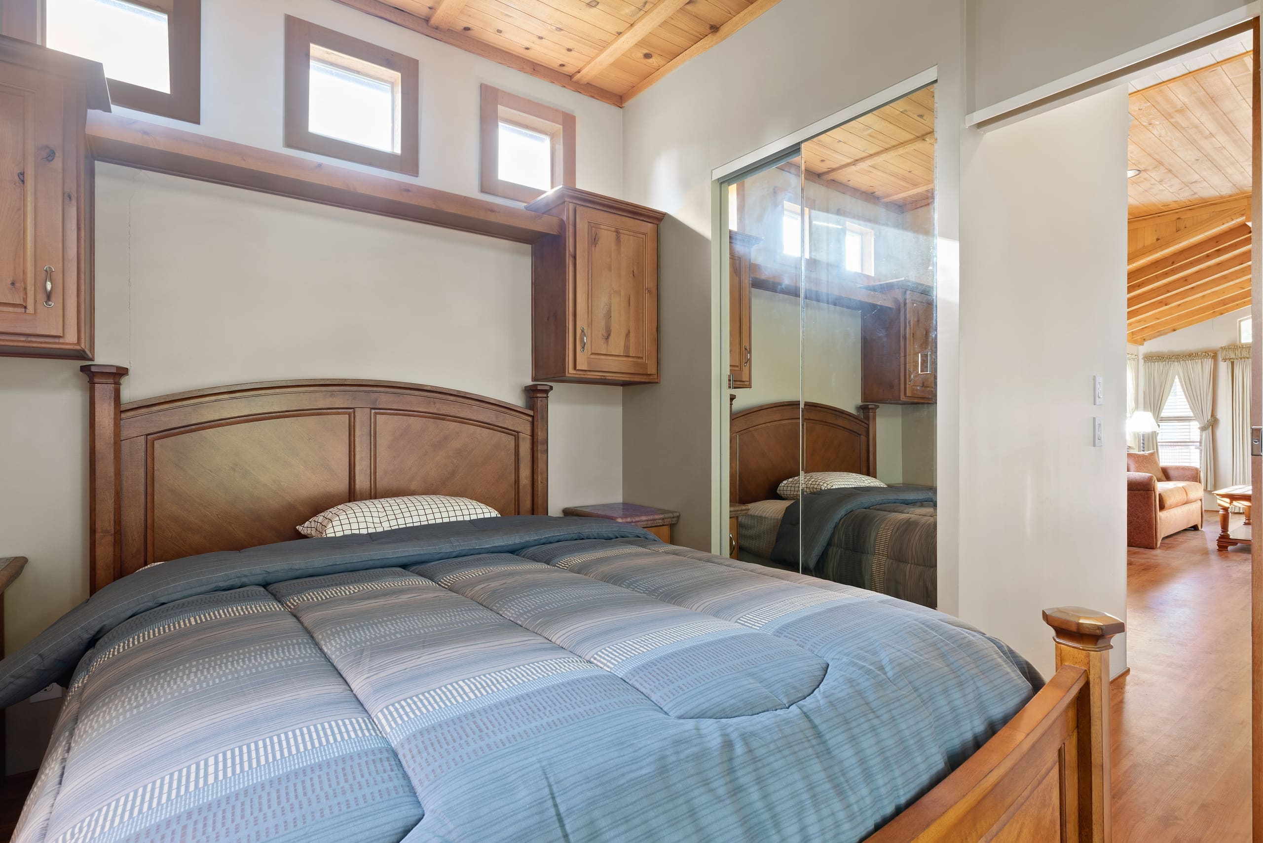 Cabin bedroom with wood headboard and blue bedding