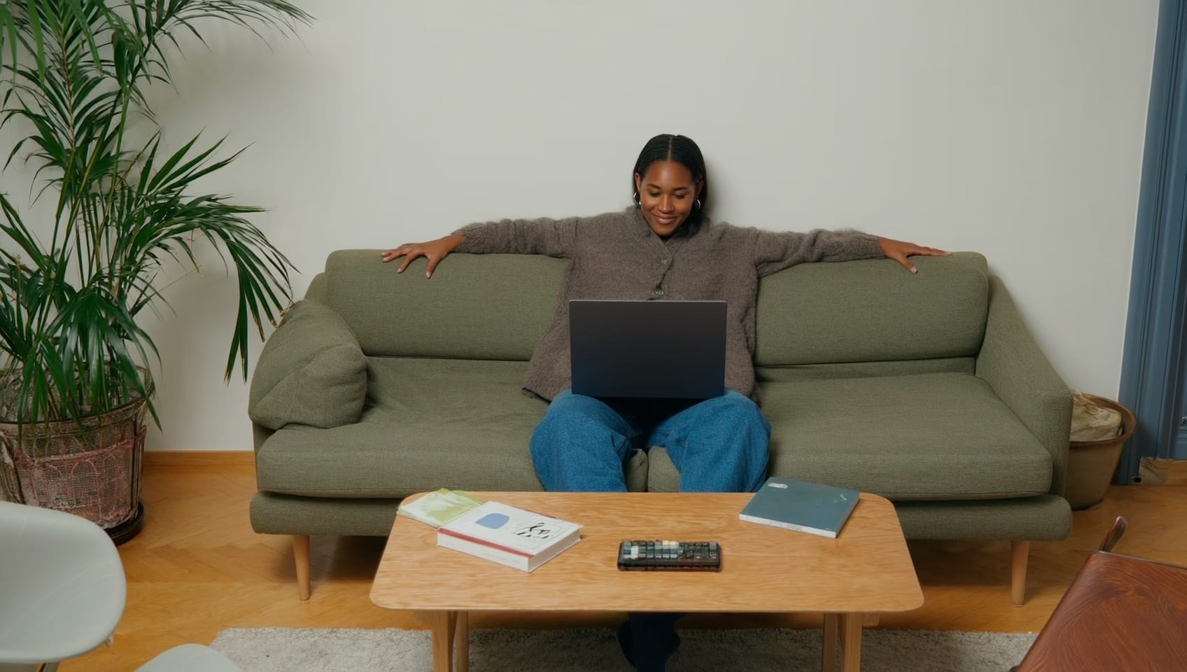 A remote worker relaxing on a cabin living room sofa with a laptop