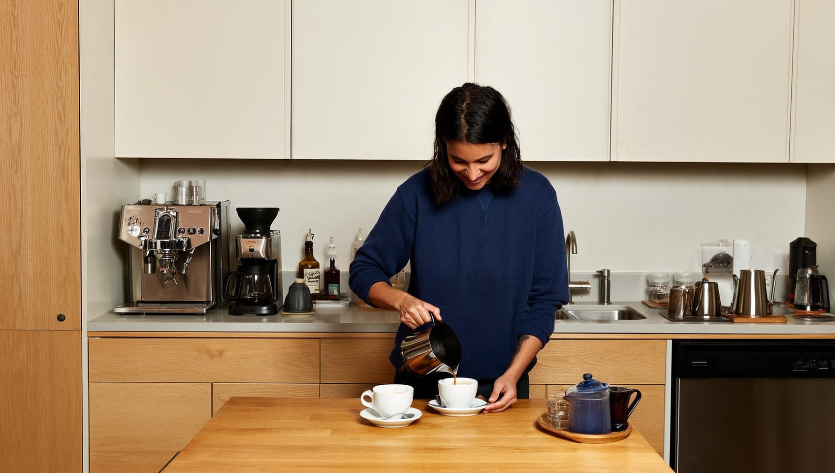 A guest making coffee in a cabin kitchen in the early morning