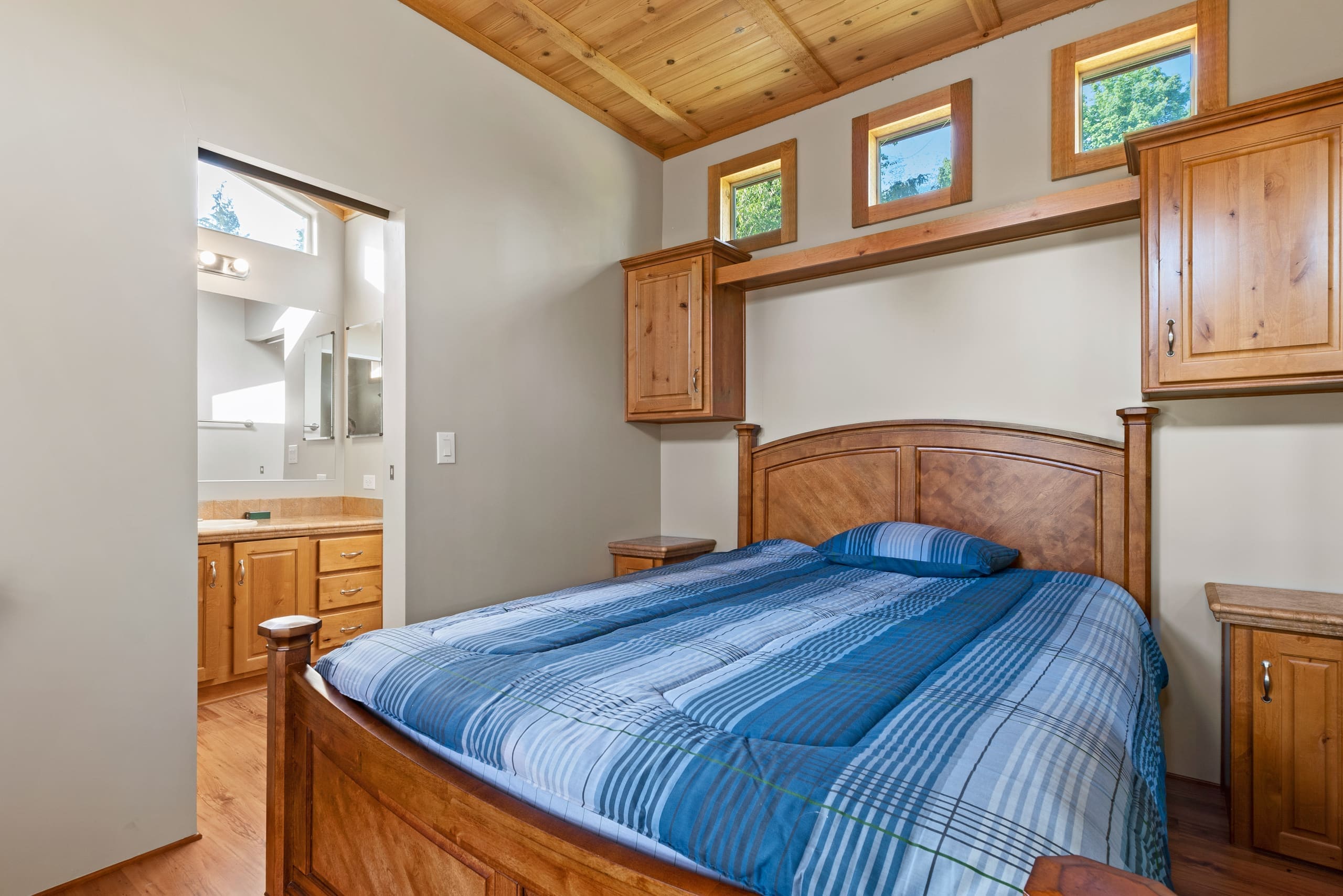 Deluxe cabin bedroom with plaid bedding and transom windows