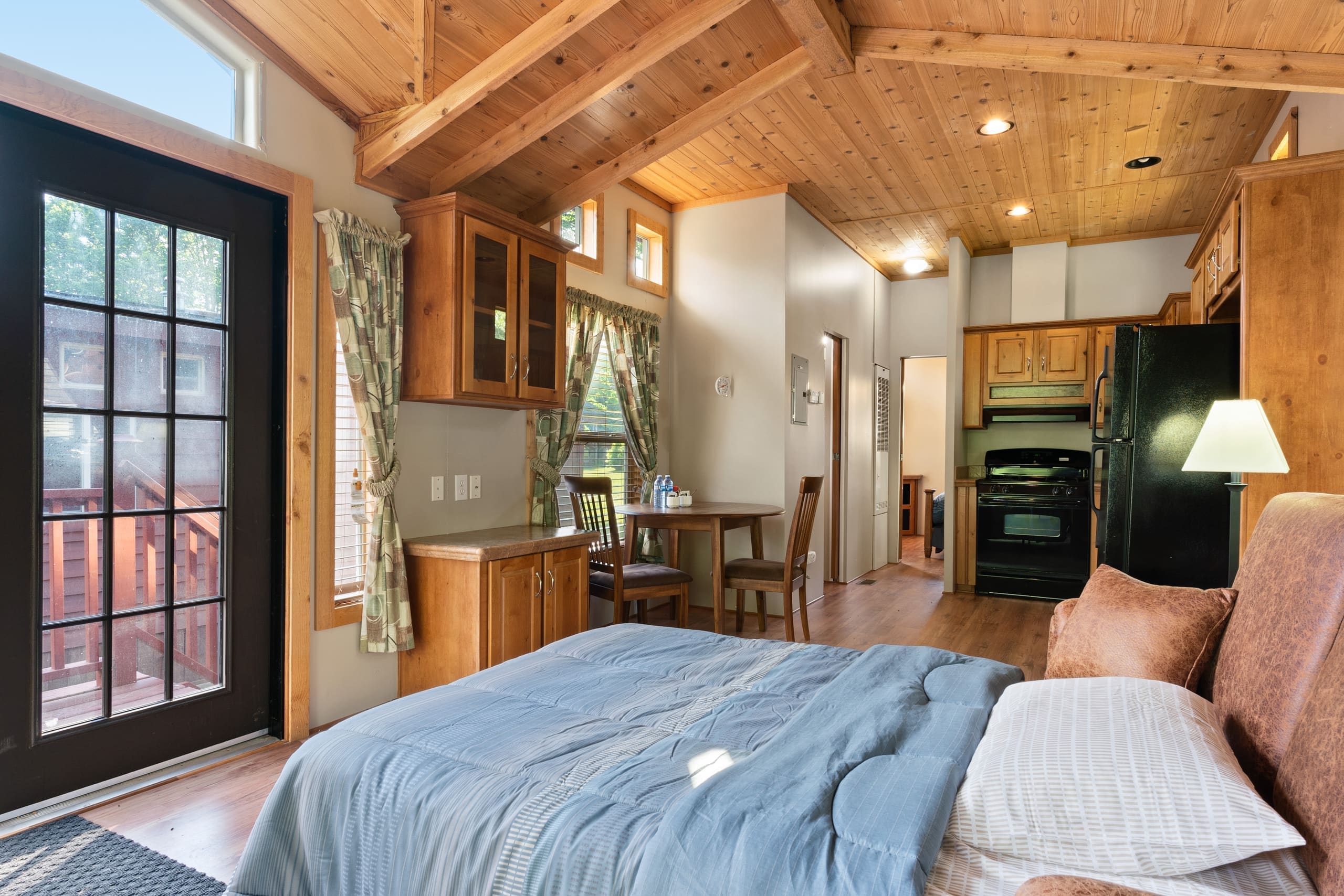 Deluxe cabin interior with bed, dining nook, and kitchen
