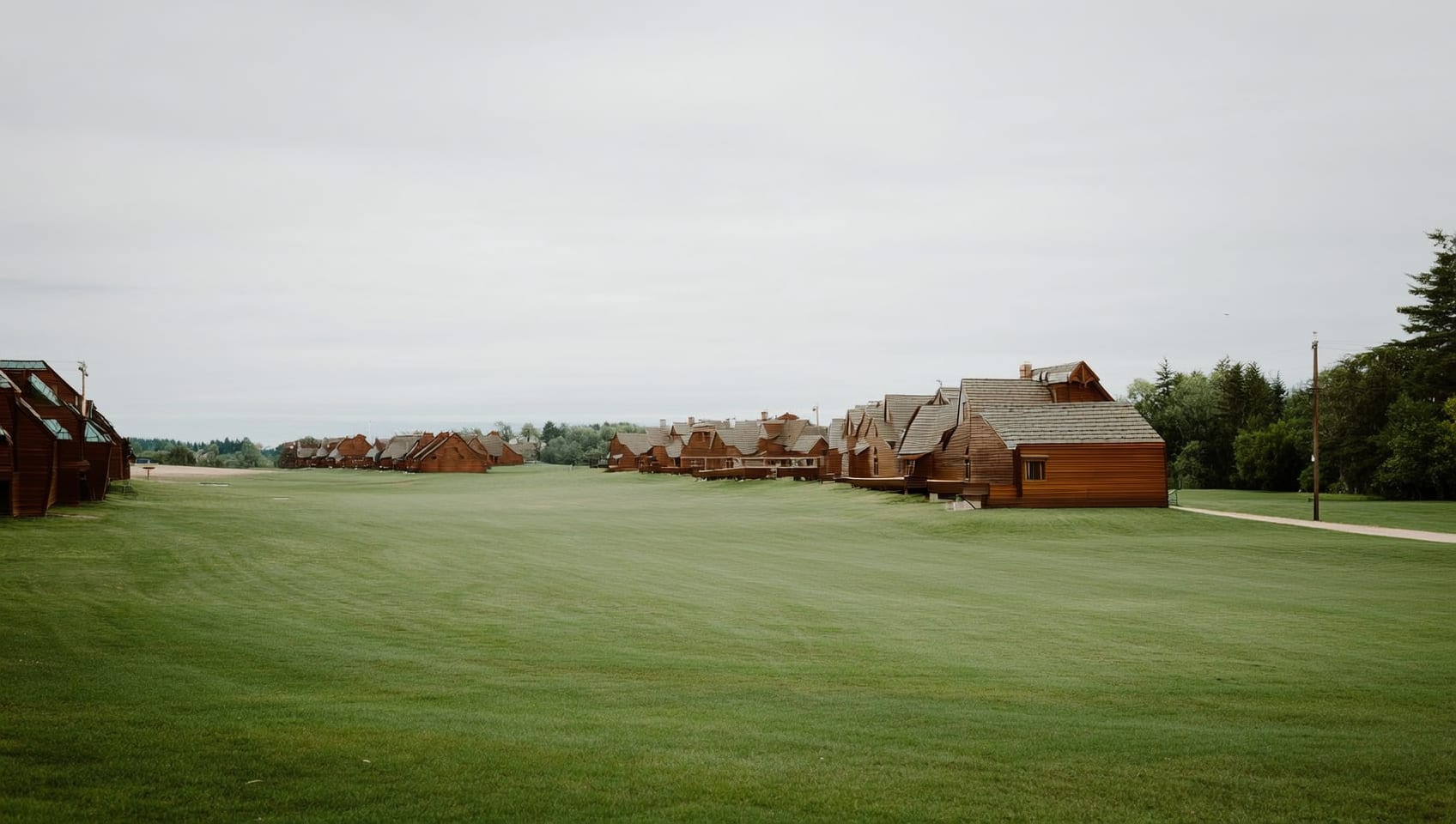 Resort lawn and gravel lane with cabins among the trees