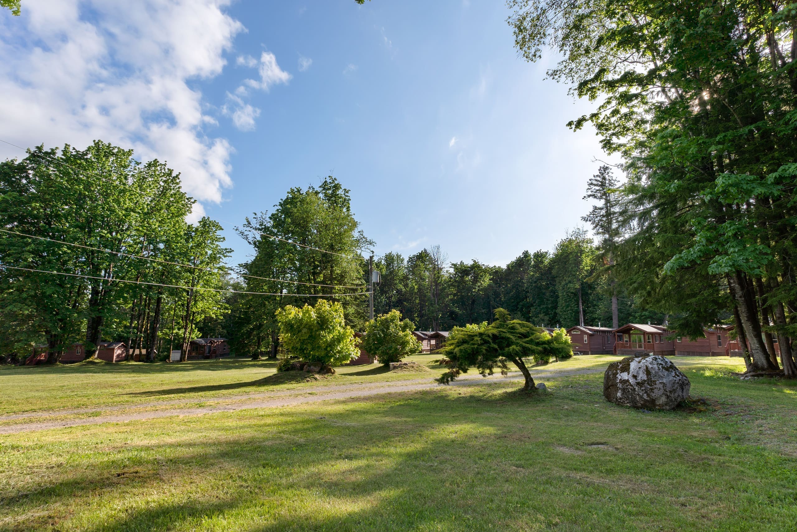 Resort lawn and gravel lane with cabins in the distance