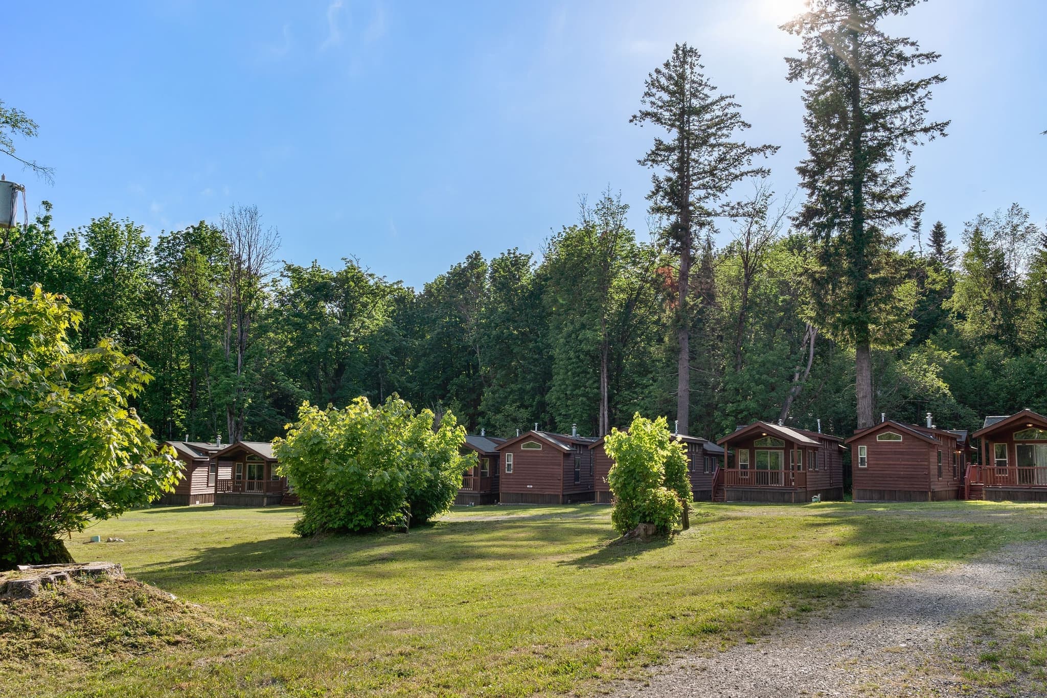 Row of cabins along the treeline on a sunny day