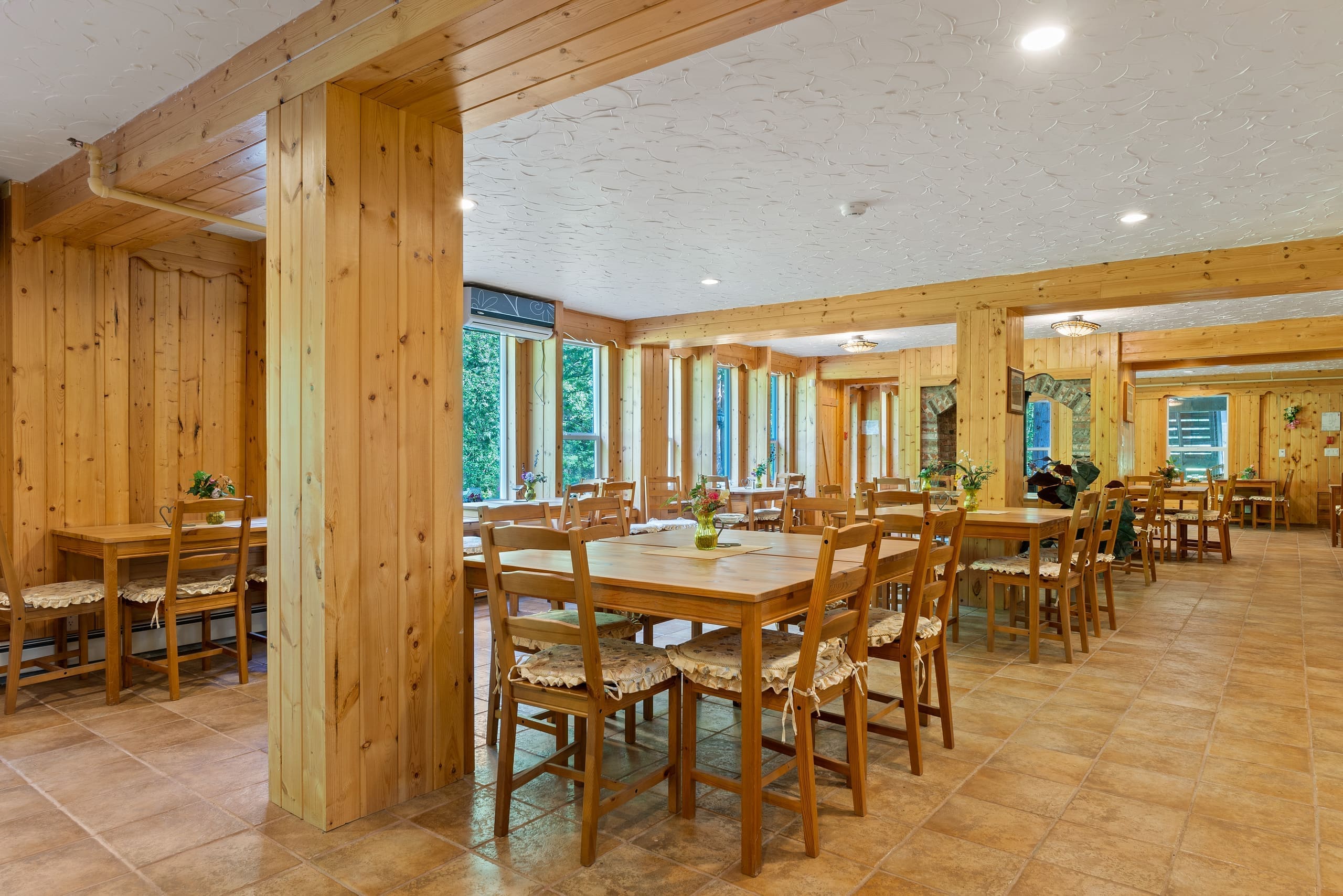 Pine-panelled dining hall with tables set for guests