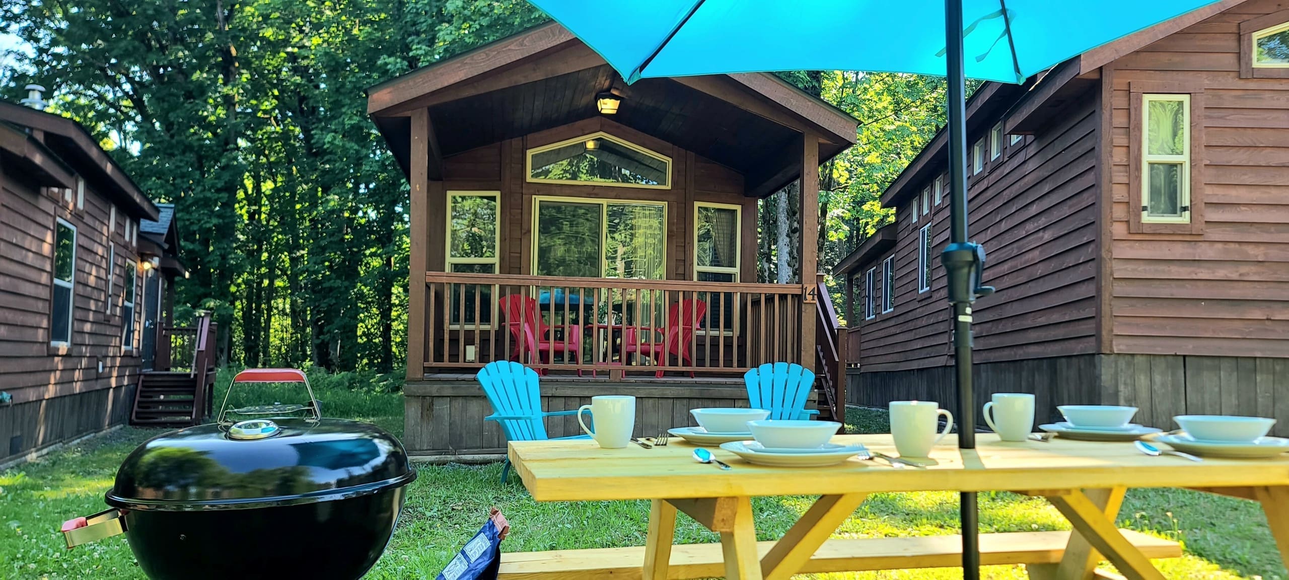 Glamping dining setup on the lawn outside a cedar cabin