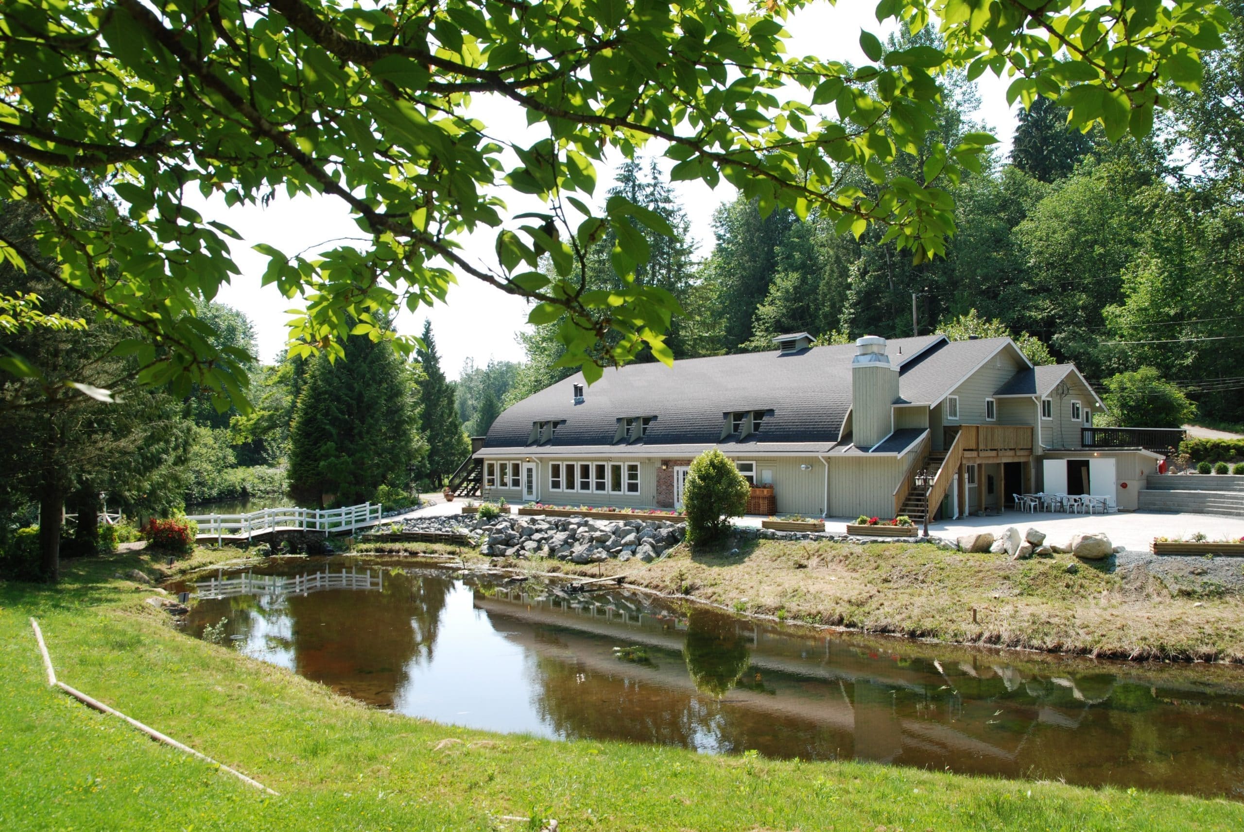 The resort lodge beside a calm pond ringed by lawns and evergreens