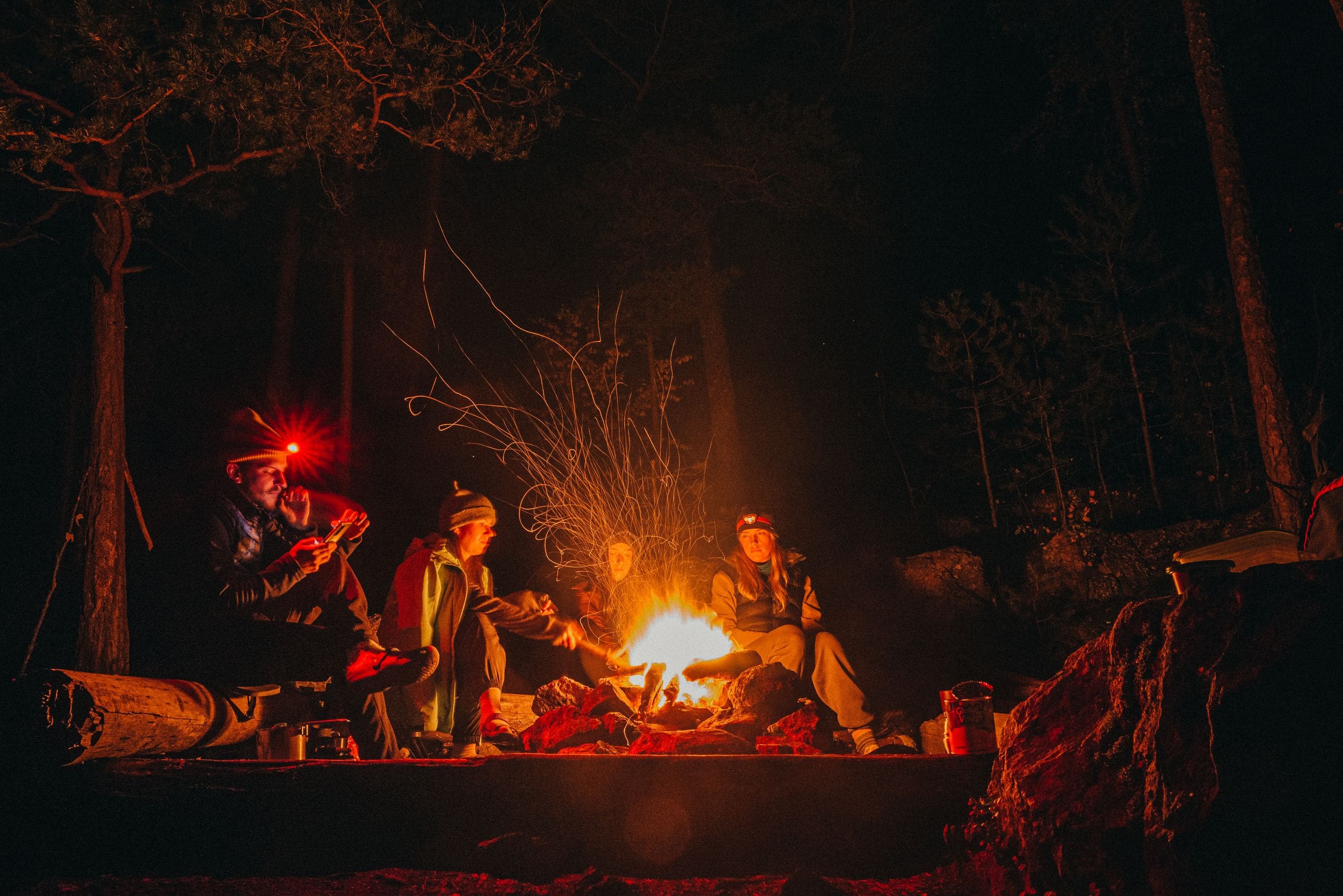 The resort team gathered around a stone fire pit at dusk